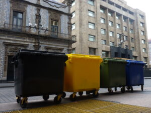 Contenedores de basura de colores colocados en una calle de la ciudad, para ilustrar los tipos de contenedores que existen.